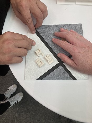 Hände fühlen das Tastmodell vom Atrium des Museums 