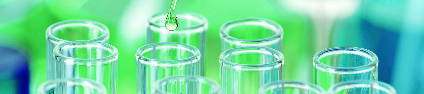 Reagenzgläser im Labor In mehrerer Reaktionsgefäße wird mit einer Pipette eine Flüssigkeit getropft.