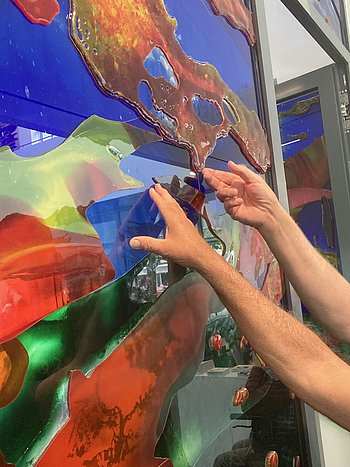 Hände tasten das Kunstwerk "Ein Glas Wasser, bitte" ab 