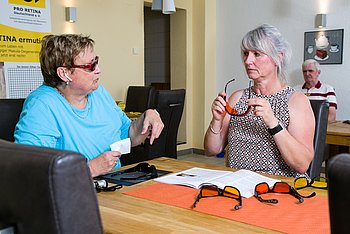 Das Bild zeigt zwei Frauen in einem Beratungsgespräch in einem Büro von PRO RETINA.