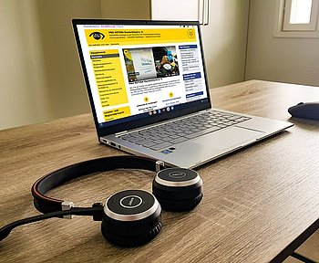 Digitalisierung ©PRO RETINA Laptop, auf dem PRO RETINA-Seite geöffnet ist. Daneben liegen Kopfhörer.