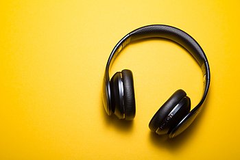 Schwarzer Kopfhörer auf gelbem Hintergund