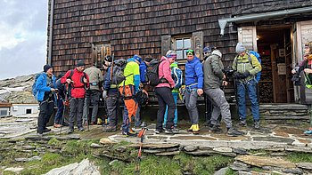 Morgens vor dem Defregger Haus warten die Wanderer auf die Ausgbe der Kletterausrüstung bevor es los geht zum Gletcher.