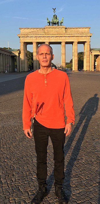 Portrait von Jörg Jörg steht vor dem Brandenburger Tor