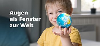Ein kleiner Junge in einem gelben T-Shirt hält einen Globis in der Hand.