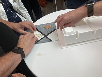 Hände tasten die Modelle vom Museum und vom Atrium ab 