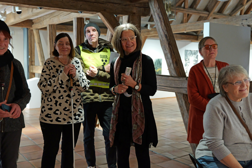 Anne, Marion, Thomas, Brigitte und Petra hören Odas Erklärungen gespannt zu. Im Hintergrund sieht man die Dachbalken des Obergeschosses.