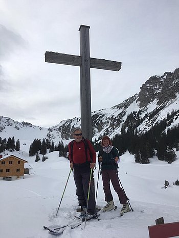 Elo Schröder-Hanisch mit ihrem Mann Elo Schröder-Hanisch mit ihrem Mann beim Skifahren vor einem Gipfelkreuz