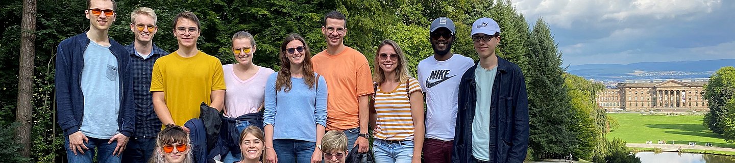 Summer Meetup der jungen Retina Eine Gruppe junger Menschen, teilweise mit Kantenfilterbrille und Blindenlangstock steht bei gutem Wetter in einem Park. Im Hintergrund sieht man ein Schloss.