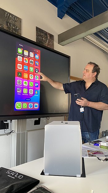 Markus Bernrieder erklärt das iPhone auf einem großen Bildschirm