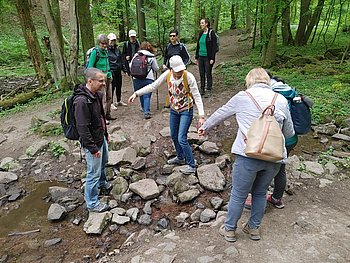 Wir helfen uns gegenseitig über Steiner in einem Bach