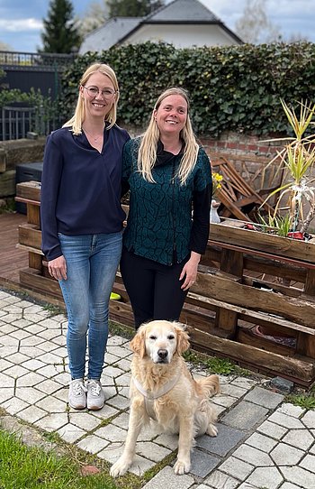 Mandy Kugel, Doreen Rottmann und Blindenführhund Nella Mandy Kugel, Doreen Rottmann und Blindenführhund Nella im Garten stehend