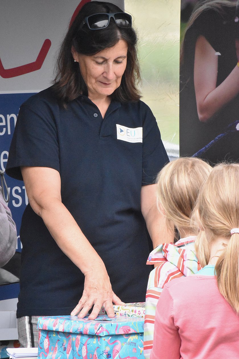 EUTB® Beraterin leitet ein Tastspiel für Kinder an. 2 Mädchen machen mit.