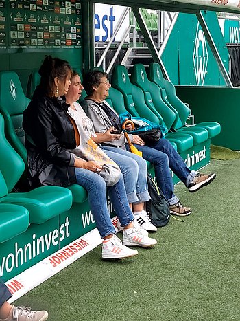 Personen sitzen auf der Ersatzbank