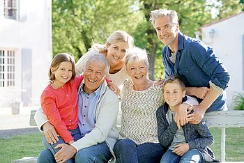 Eine Mehrgenerationenfamilie sitzt auf einer Bank